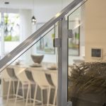 Glass railing system posts and handrail in stainless steel close up of hardware Glass railing system posts and handrail in stainless steel close up of hardware